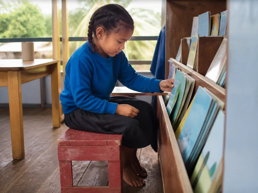 Enfants choisissant librement des livres colorés dans une bibliothèque chaleureuse